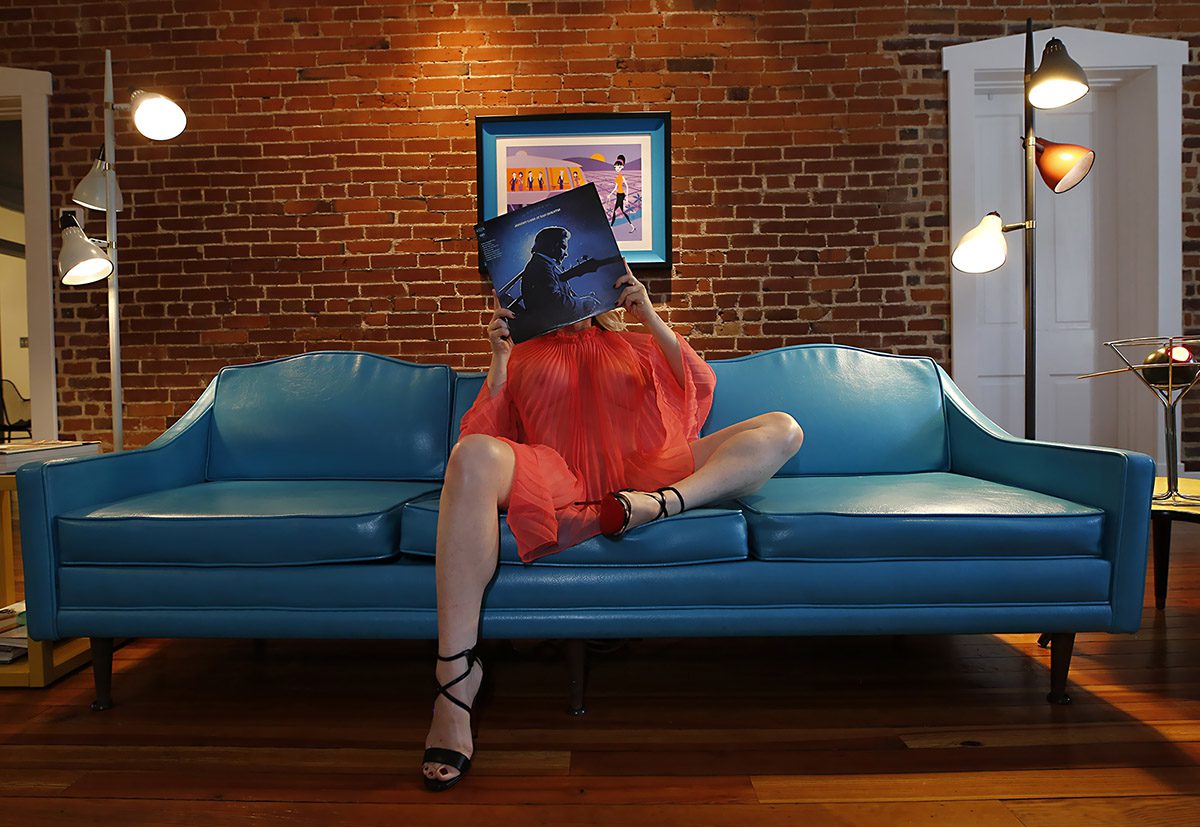 Megan Love sitting on a blue couch