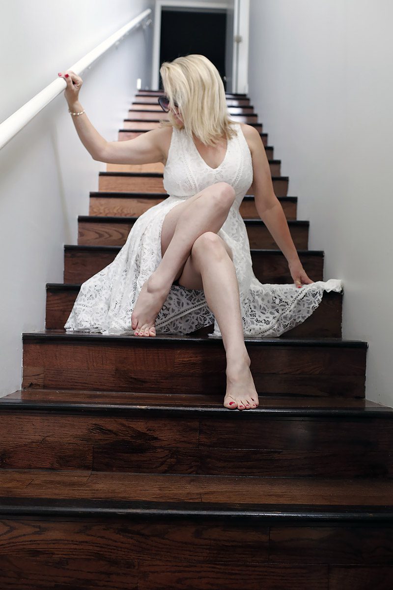 Megan Love in white dress on stairs