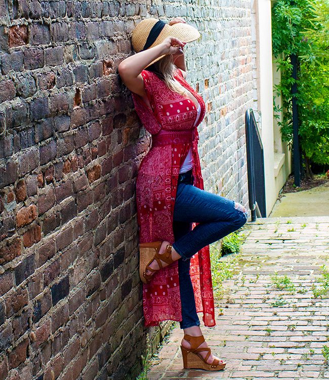Chattanooga escort, Megan Love, posing in jeans and leaning on a brick wall