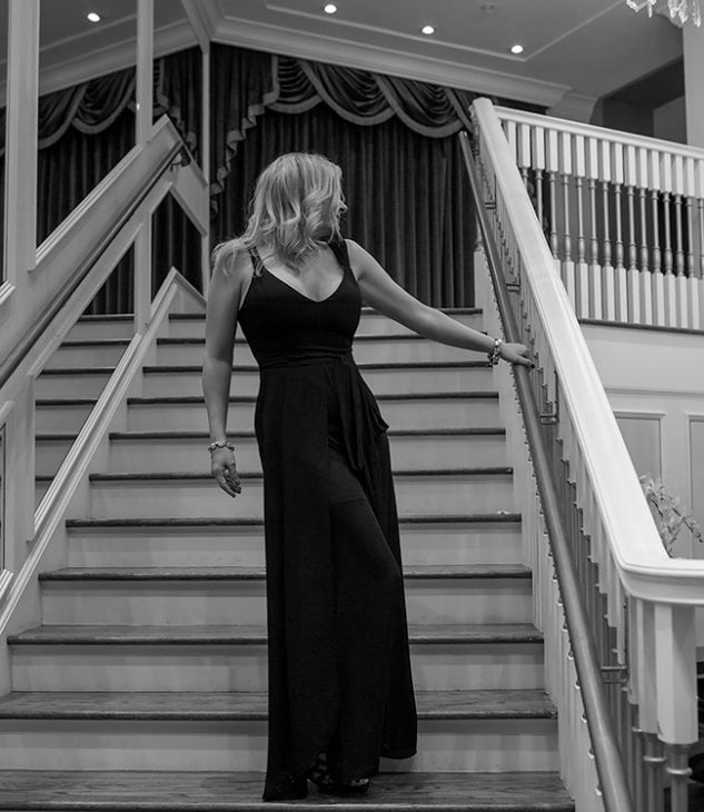 Megan Love, mature Charlotte Escort in black dress standing on staircase